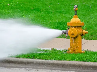 water flushing from a yellow fire hydrant